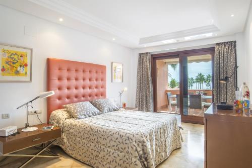 a bedroom with a king sized bed and a desk at Beach front apartment Mar Azul in Estepona