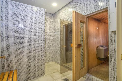 a bathroom with a walk in shower with a glass door at Beach front apartment Mar Azul in Estepona