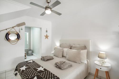 a white bedroom with a bed with a ceiling fan at Estrella Del Mar Amazing Loft Casa in Mogán