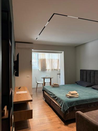 a bedroom with a bed and a table in it at Downtown Apartment Rooms in Tirana