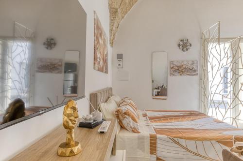a bedroom with a bed and a table and mirrors at Casa Don Michele in Specchia