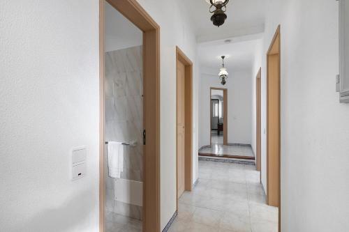 a hallway with white walls and a white tile floor at Villa Martins in Albufeira