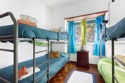 a bedroom with bunk beds and a window at Casa Campo e Mar in Encarnação