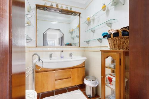 a bathroom with a sink and a mirror at Casa Campo e Mar in Encarnação