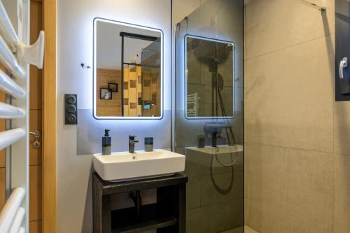 a bathroom with a sink and a mirror at Le chalet Amélie in La Bresse