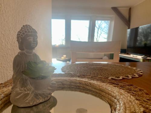 a statue of a buddha sitting on a table at Haevn-Erholung, Fewo Südsonne in Reußenköge