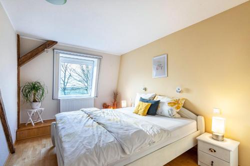a bedroom with a large bed and a window at Haevn-Erholung, Fewo Südsonne in Reußenköge
