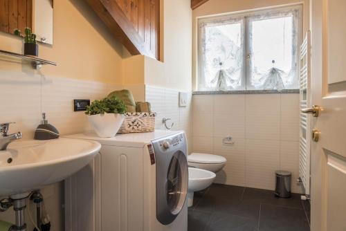 a bathroom with a washing machine and a sink at Maison Vittoria Lago Maggiore in Laveno-Mombello