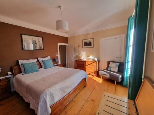 a bedroom with a large bed with blue pillows at Cour Du Weinhof à Colmar in Colmar