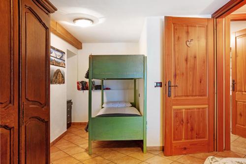 a green bunk bed in a room with a door at Maison Cerise Pila in Gressan