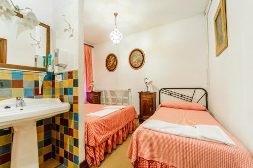 a bathroom with two twin beds and a sink at El chalet El uncar in Castrejón de la Peña
