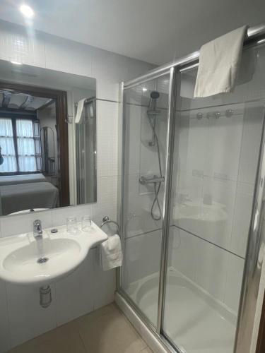 a bathroom with a glass shower and a sink at Hostal Rey Pedro I in Santo Domingo de la Calzada