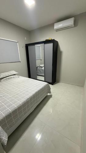 a bedroom with a bed and a mirror at Casa em tibau in Tibau