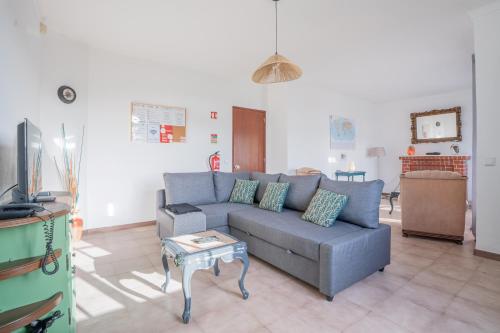 a living room with a blue couch and a table at Casa das 3 Marias in Biscoito Bravo