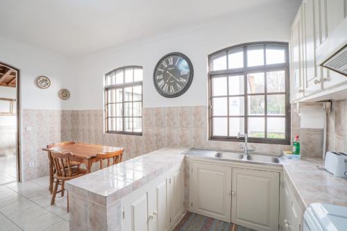 a kitchen with a sink and a clock on the wall at Casa das 3 Marias in Biscoito Bravo