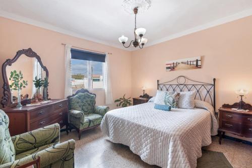 a bedroom with a bed and a chair and a mirror at Siempreviva in Gáldar
