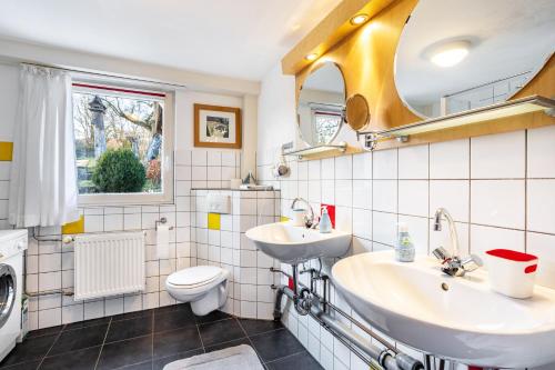 a bathroom with two sinks and a toilet at Ferienhaus Titz in Sundern