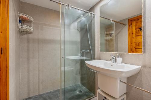 a bathroom with a glass shower and a sink at El Tesorillo Andalúz in Almuñécar