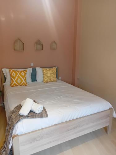 a bedroom with a large white bed with towels on it at Christi Iuxury Apartment in Preveza