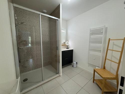 a bathroom with a shower and a wooden chair at Appartement Autza 6 voyageurs proche des plages in Moliets-et-Maa