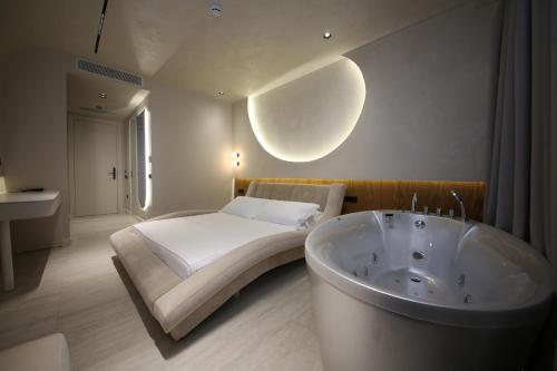 a bedroom with a bed and a bath tub at Coral Boutique Hotel in Vlorë