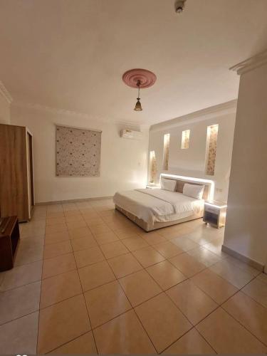 a large bedroom with a bed and a tiled floor at شاطئ الحوية in Taif