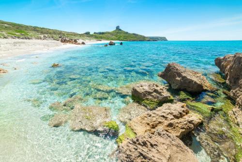 a view of a beach with rocks in the water at Blue Horizon Sinis in Funtana Meiga