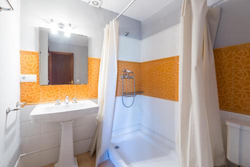a bathroom with a white sink and a shower at Can Divertit in Port de Soller