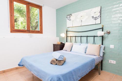 a bedroom with a bed with a hat on it at Can Divertit in Port de Soller
