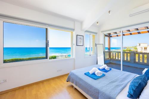 a bedroom with a bed with a view of the ocean at Villa Bella Ena in Nea Dimmata