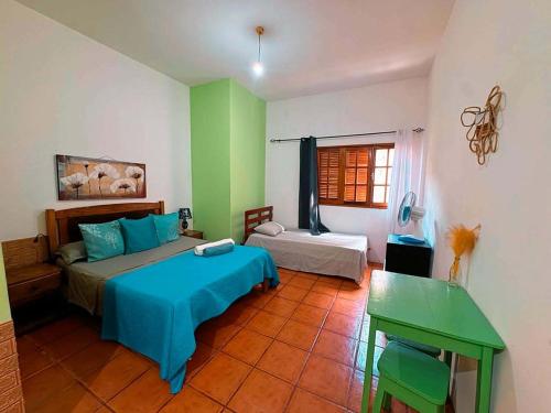 a bedroom with two beds and a green and white wall at Divin'Art in Tarrafal da Vila de Ribeira Grande