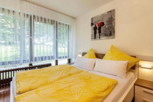 a bedroom with a yellow bed and a window at Ferienwohnung Fetscher 2 in Reichenau