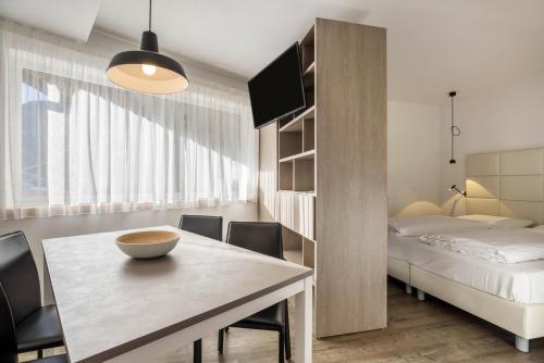 a room with a dining table and a bed at Apartment Dui Residence Bun Ste in San Vigilio Di Marebbe
