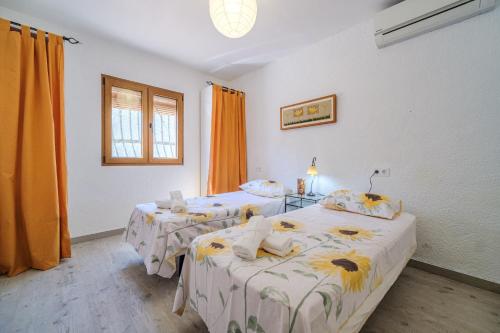 two beds in a room with orange curtains at Romántica Jávea -Solo Familias 1769 in El Tosalet