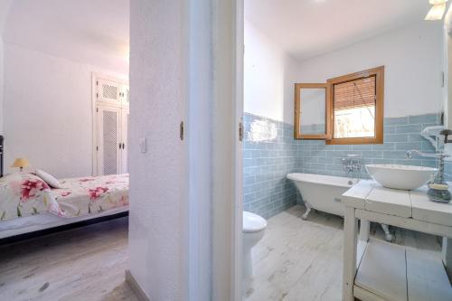 a bathroom with a tub and a sink and a bed at Romántica Jávea -Solo Familias 1769 in El Tosalet