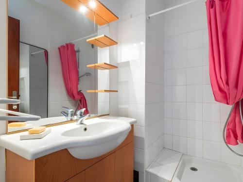 a bathroom with a sink and a red shower curtain at Maison de la plage in Valras-Plage