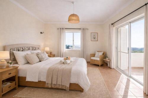 a bedroom with a bed and a large window at Villa with beautiful sea views, pool & spacious gardens & great for remote work in Ferragudo