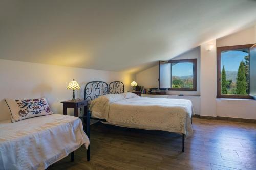 a bedroom with two beds and two windows at Etnalodge in Piedimonte Etneo