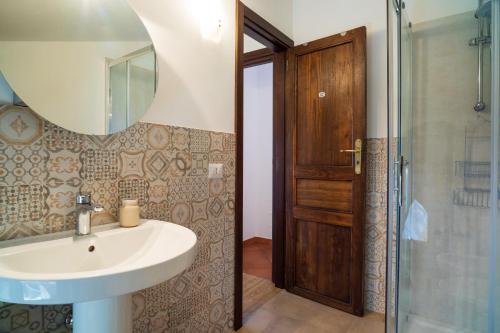 a bathroom with a sink and a shower and a mirror at Etnalodge in Piedimonte Etneo