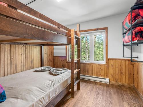 a bedroom with two bunk beds and a window at Rustic & Charming Mont Blanc Chalet Private Spa in Saint-Faustin