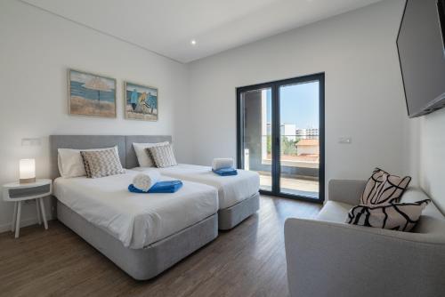 a living room with two beds and a couch at Luxury T2 Apartment With Ocean View in Portimão