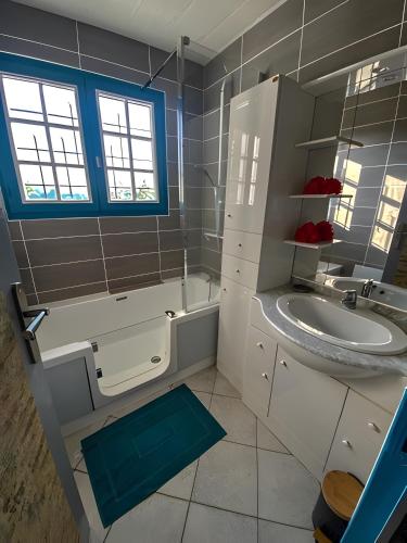 a bathroom with a sink and a toilet and a tub at Gîte de Lonzanges in Lanobre