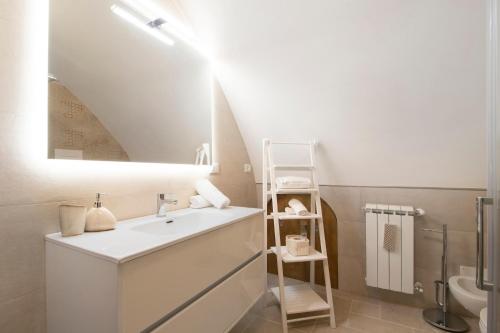 a white bathroom with a sink and a mirror at Casa Tuccia in Ostuni