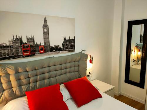 a bedroom with a bed with red pillows and big ben at Erudito in Valencia