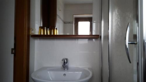 y baño con lavabo y espejo. en Maison Rosalp, en Breuil-Cervinia
