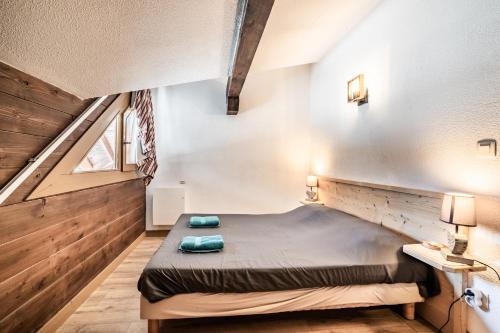 a small bedroom with a bed in the middle of the room at Chalet Triplex avec Piscine - Sauna in Samoëns