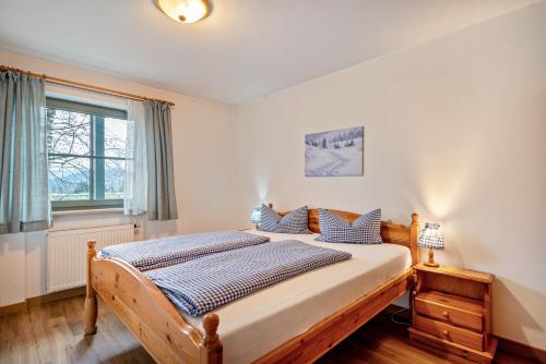 a bedroom with a bed and a window at Fewo Brünnstein - Nr 40 Pool, Sauna in Oberaudorf