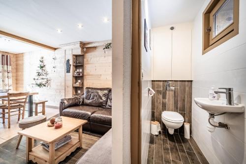a living room with a couch and a table at Chalet Triplex avec Piscine - Sauna in Samoëns