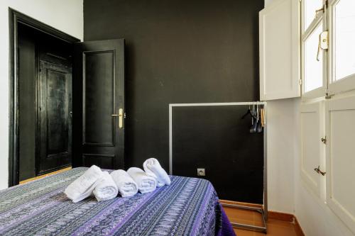 a room with a bed with white towels on it at Conde Center Premium Suites in Seville