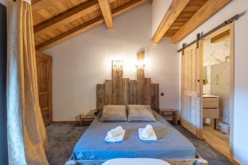 a bedroom with a bed in a room with wooden ceilings at Albert le Cerf in Morillon